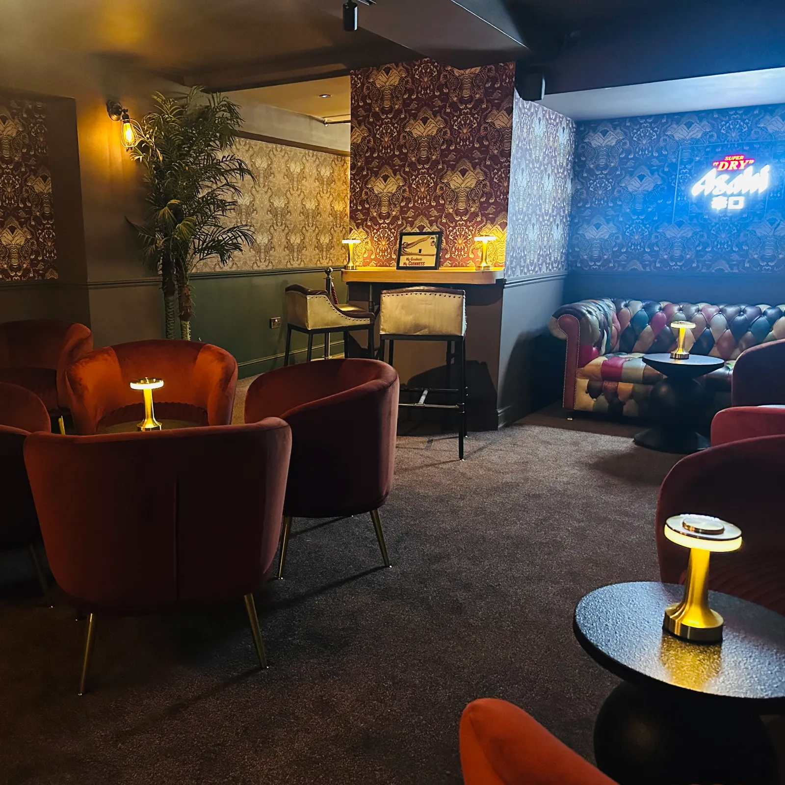 Velvet chairs and soft lighting in the lounge at The Suffolk Hotel